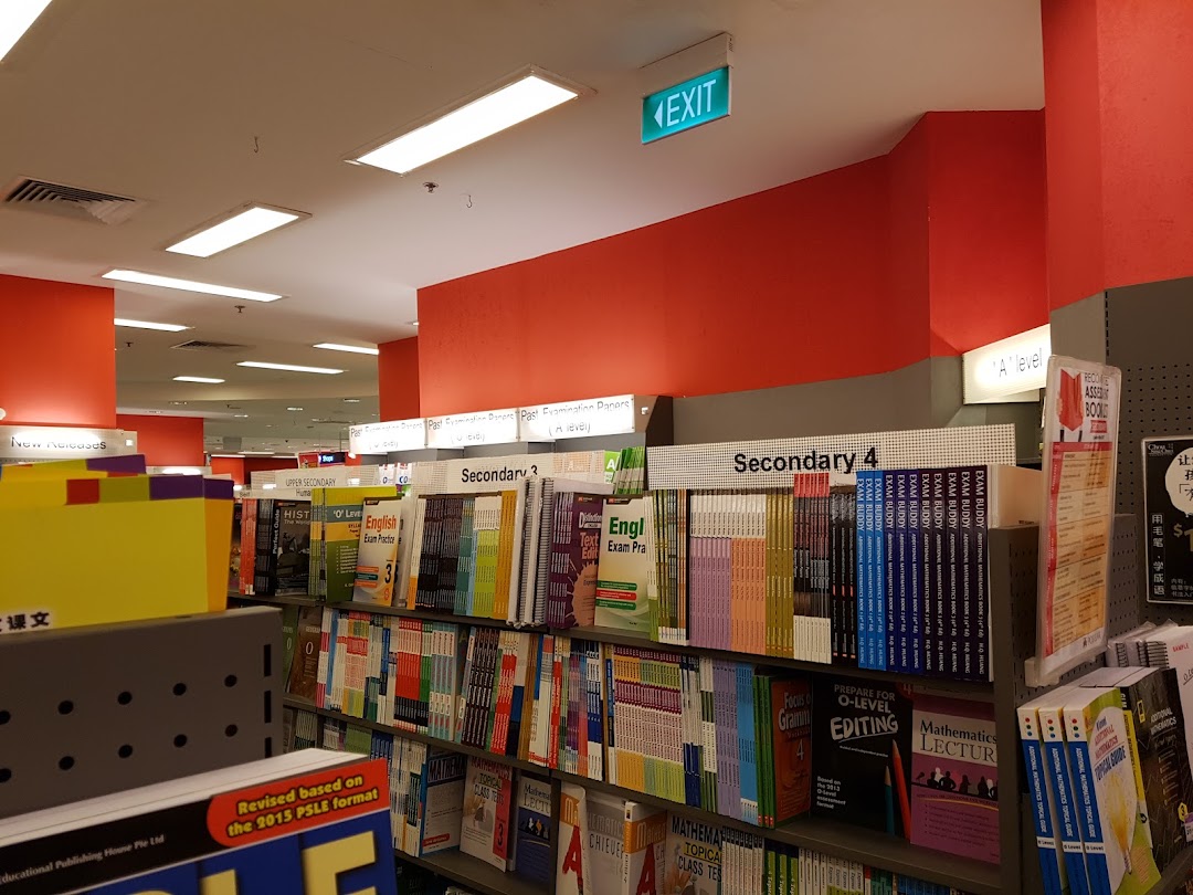Interior view of a bookstore with shelves full of academic books and an exit sign.