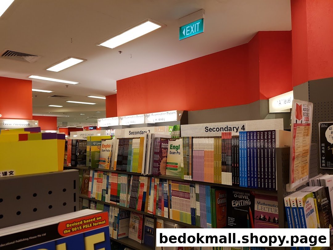 Interior view of a bookstore with shelves full of academic books and an exit sign.