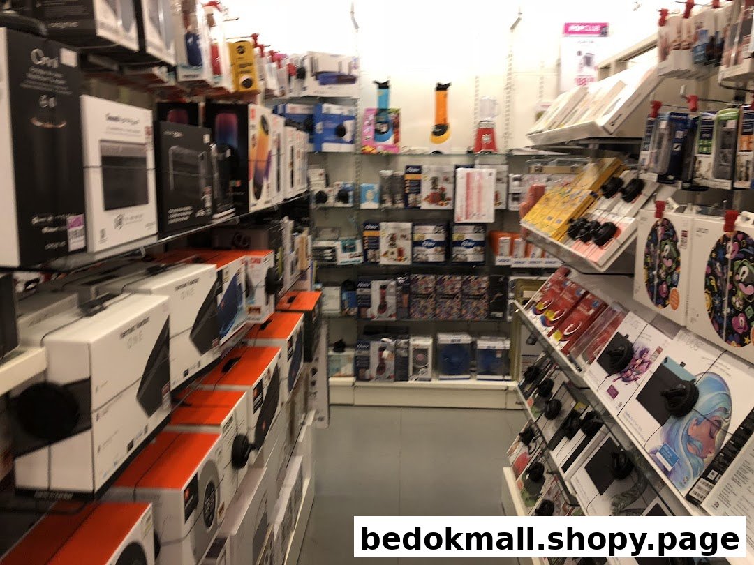Interior view of a retail store aisle with shelves of electronics and accessories.