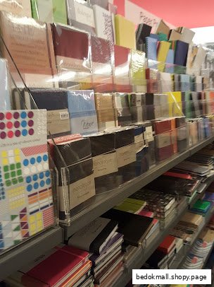 Shelves filled with various notebooks and stationery items in a store.