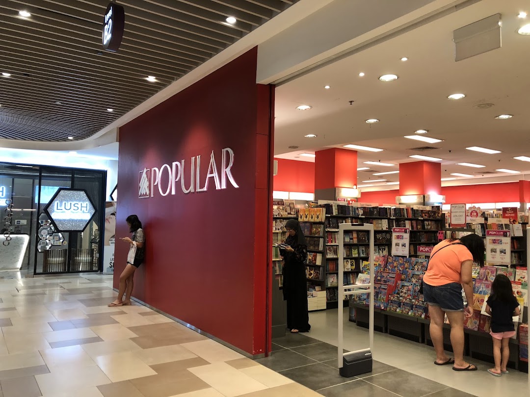 Entrance of POPULAR bookstore with its logo and people inside.