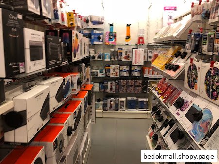 Interior view of a retail store aisle with shelves full of various products.