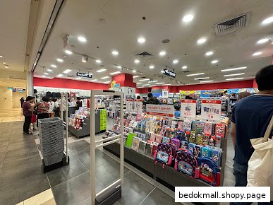 Interior view of a bookstore with shelves of products, customers, and anti-theft gates.