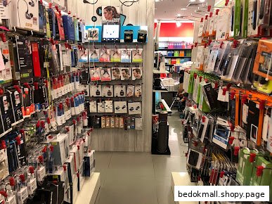 Interior view of a retail store aisle with shelves stocked with electronic accessories.