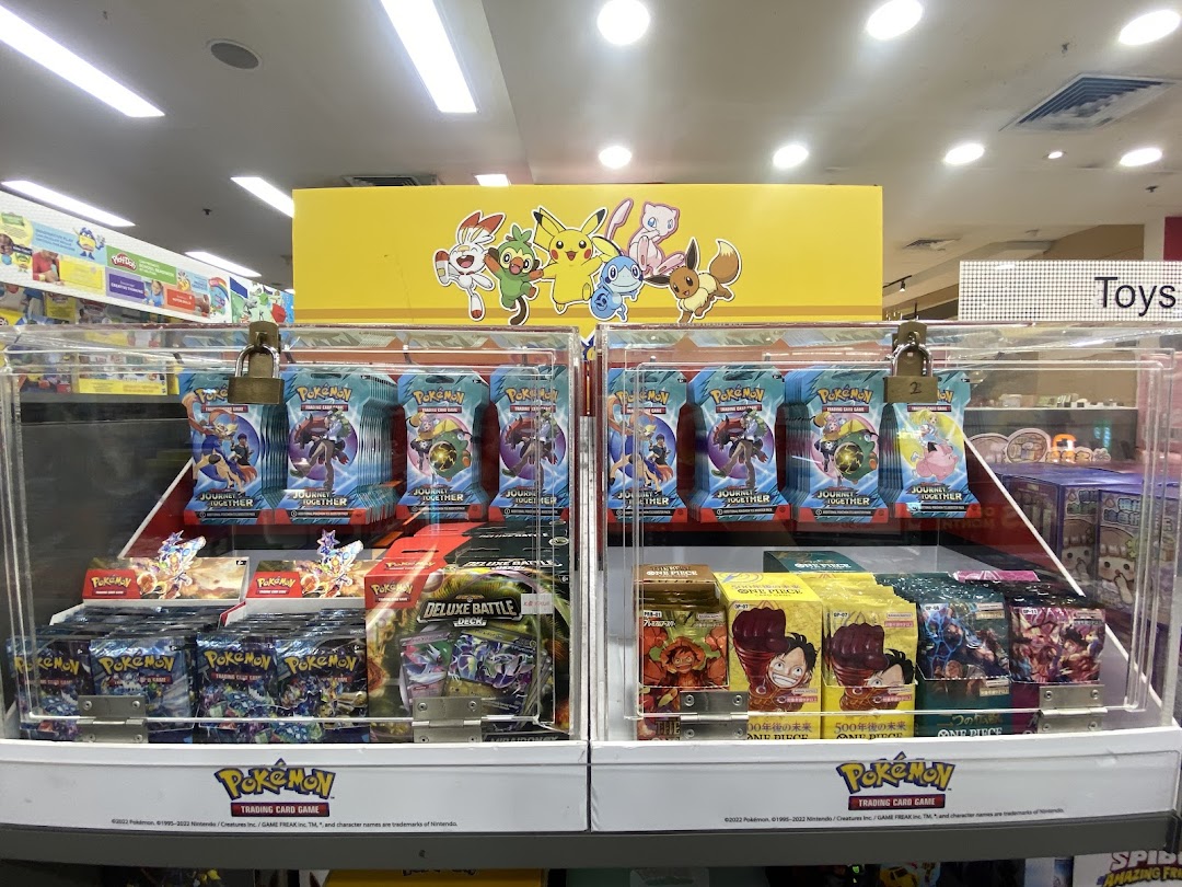A display case filled with Pokemon and One Piece trading cards inside a shop.