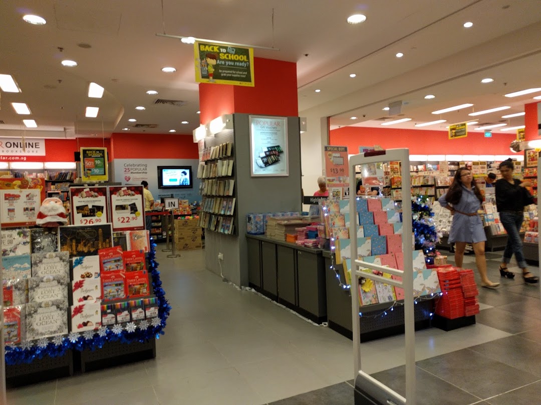Interior view of a bookstore with books, displays, and customers browsing.