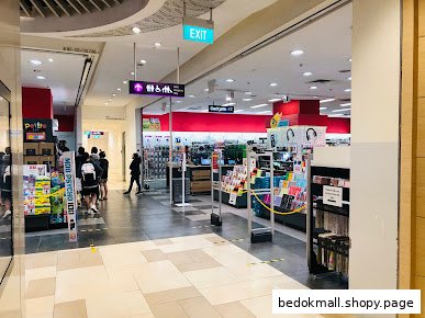 Interior view of a bookstore entrance with security gates and various products.