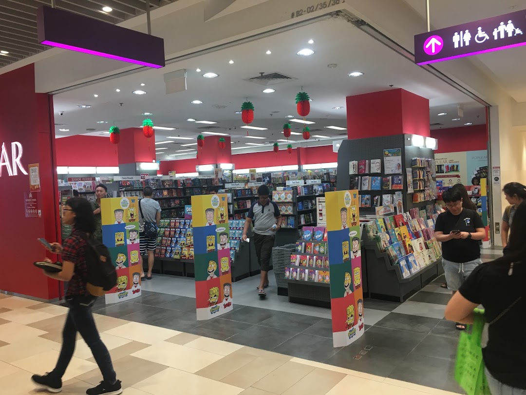 Entrance of a bookstore with people browsing books and merchandise.