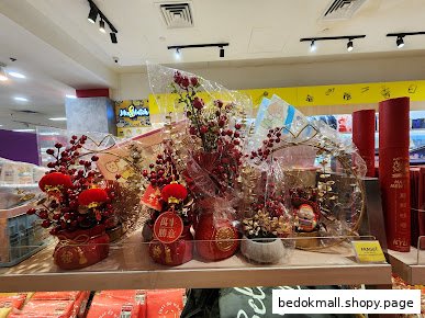 Shelf displaying red festive decorations inside a bookstore.