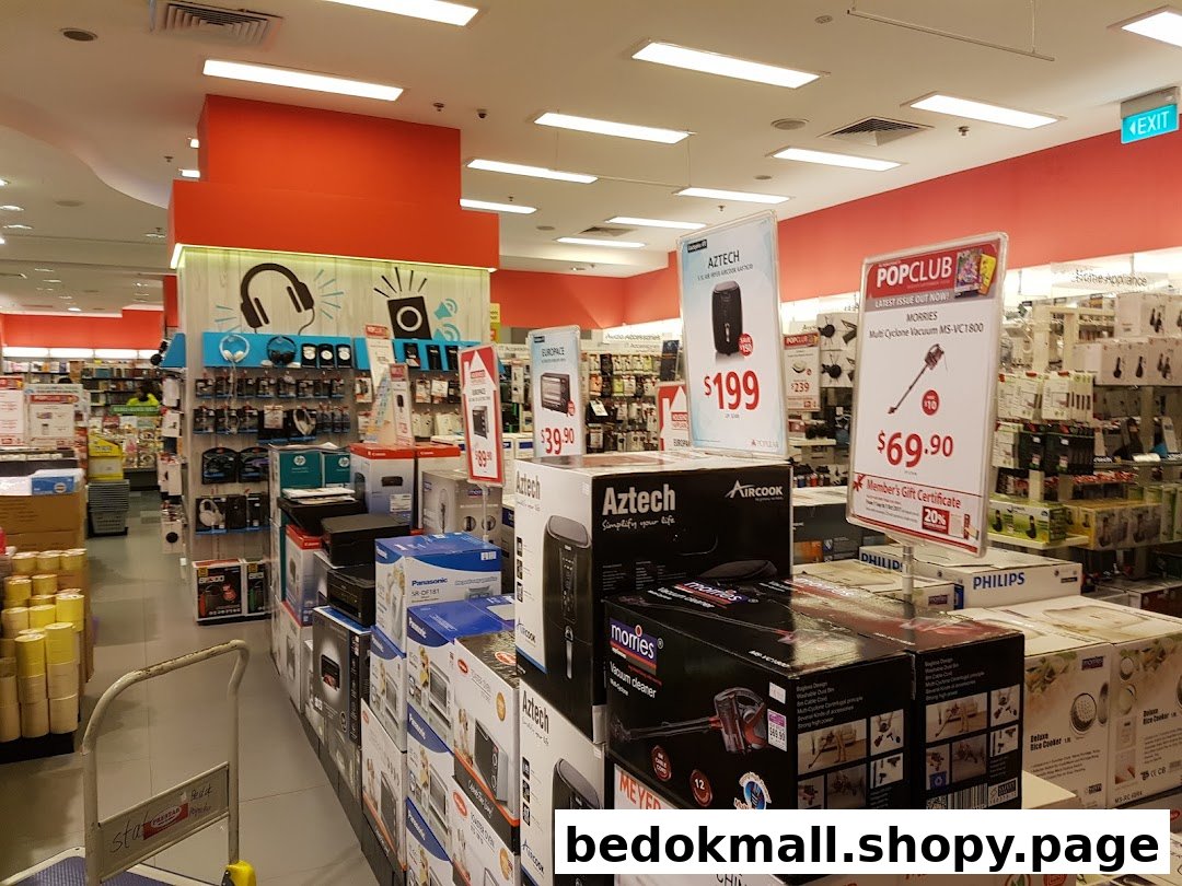 Interior view of a retail store with electronics, appliances, and promotional displays.