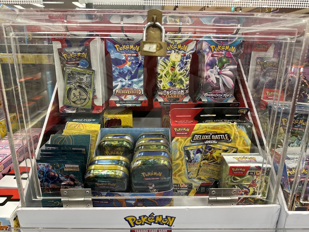 A locked display case filled with various Pokémon trading card game products.