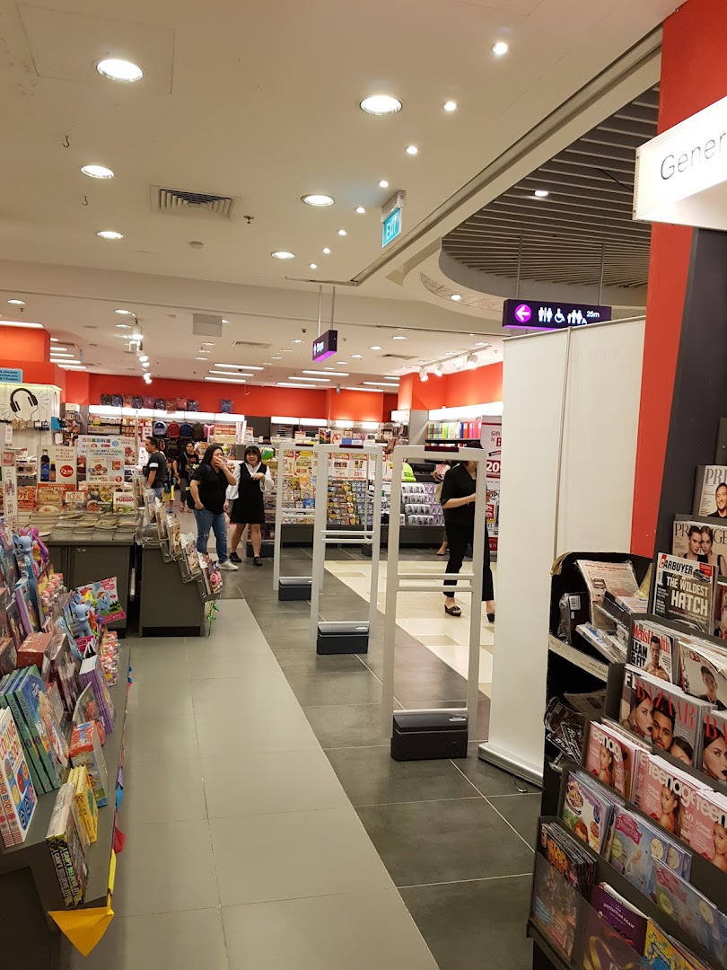 Interior view of a bookstore with shelves, people, and security gates.