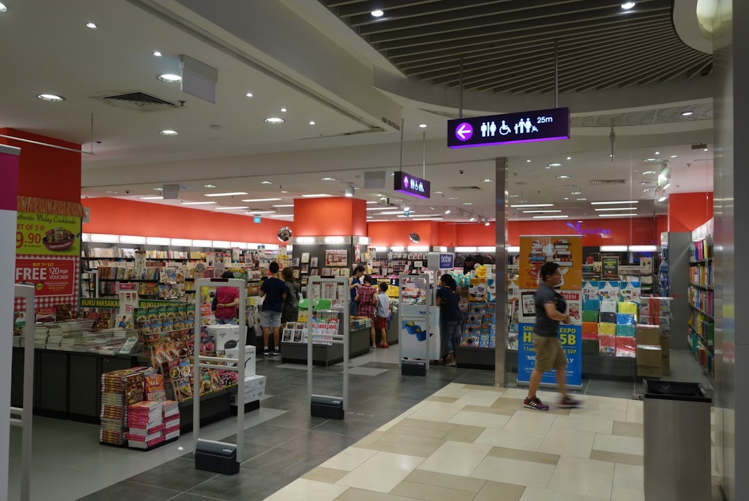 Interior of a bookstore with customers browsing books and promotional displays.