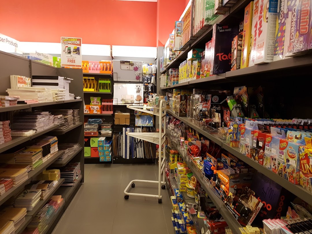 Interior view of a bookstore aisle with shelves stocked with books, stationery, and games.