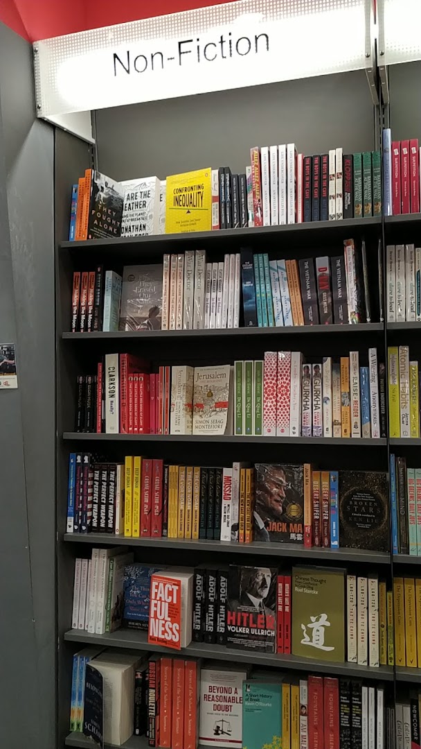 A bookshelf filled with non-fiction books in a bookstore.