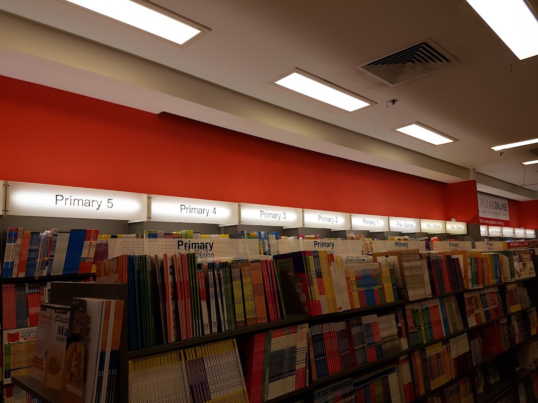 Interior view of a bookstore with shelves of educational books categorized by primary levels.