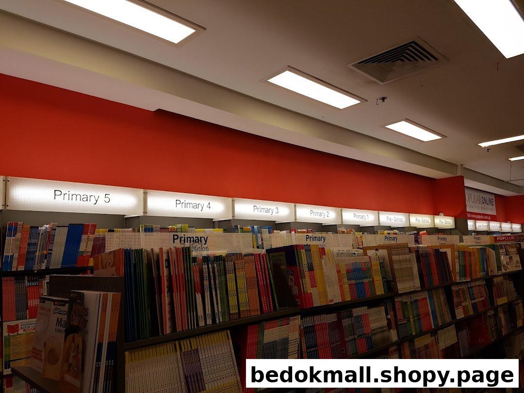 Interior view of a bookstore with shelves of educational books categorized by primary levels.