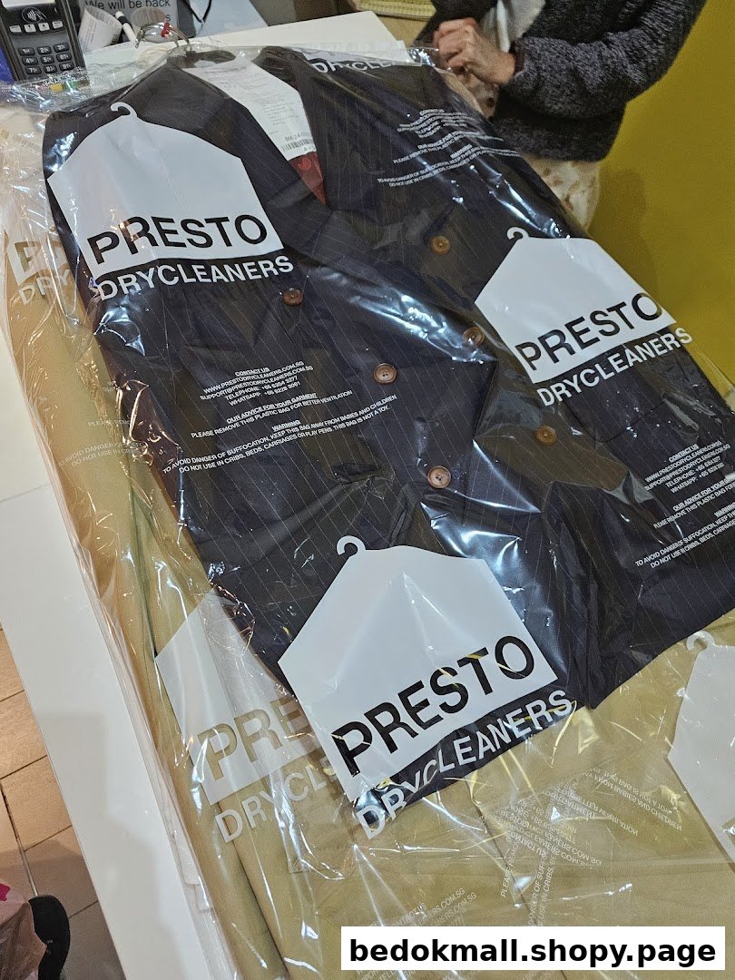 Dry-cleaned clothes in plastic bags on a counter.