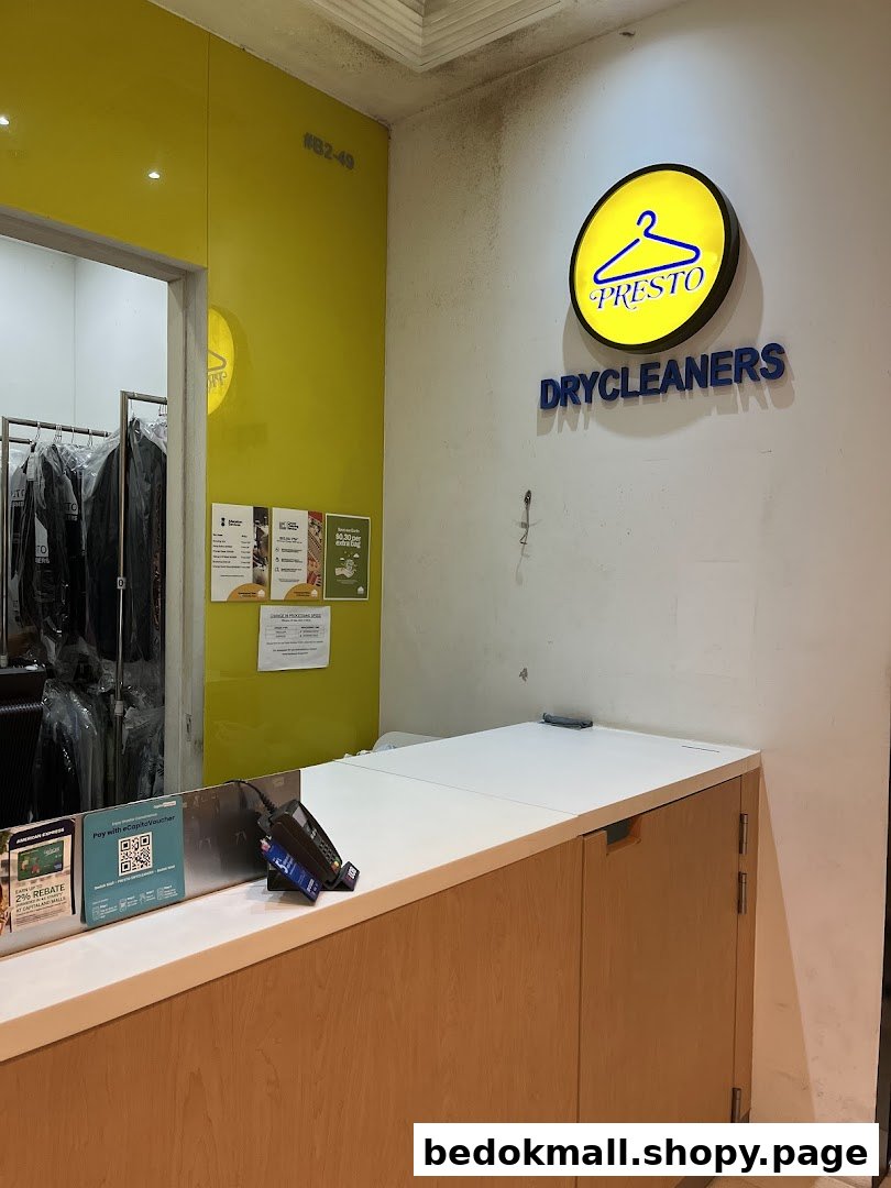 Interior view of a drycleaners shop with a counter and sign.