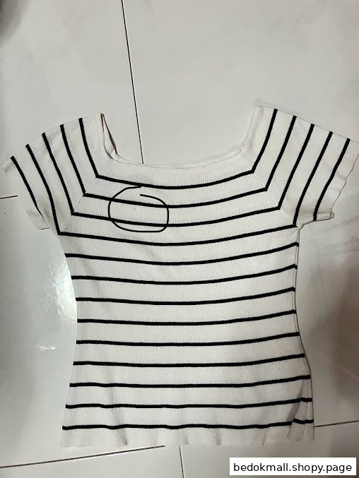 White and black striped top with a circled mark on the front.