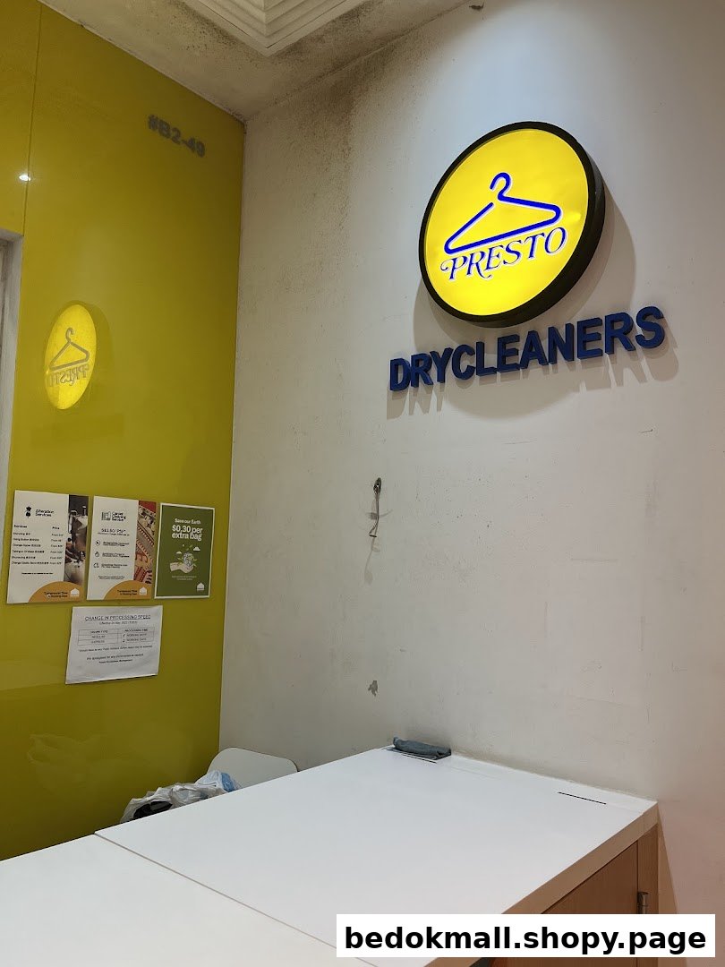 Interior view of a dry cleaner shop with a counter and wall signage.