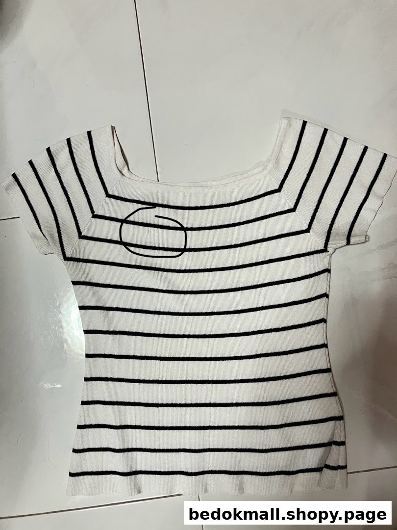 White and black striped top with a marked spot on the chest.