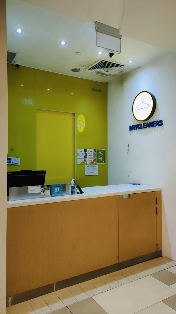 Dry cleaner's reception area with a counter and brand signage.