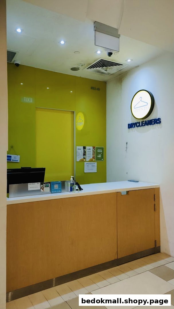 Dry cleaner's reception area with a counter and brand signage.