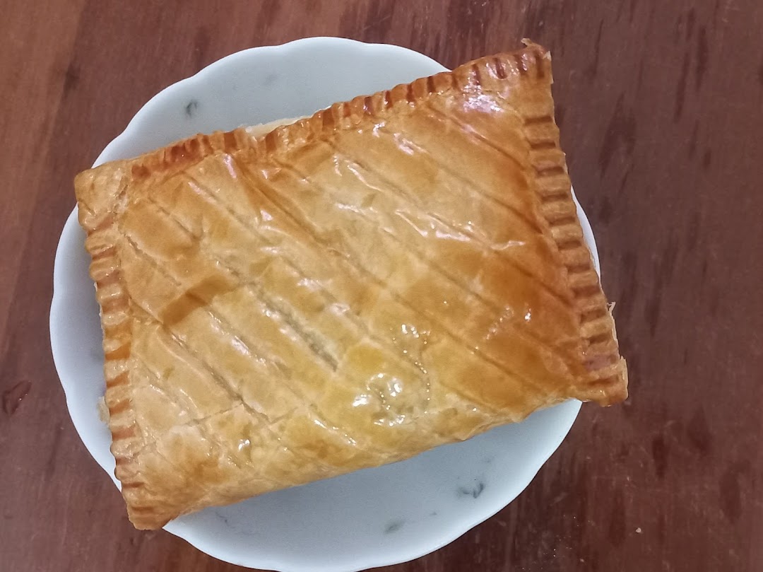 A golden-brown rectangular pastry on a white plate, viewed from above.