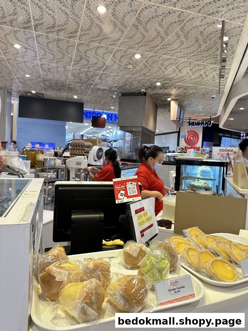 Shop interior with staff, baked goods on display, and a counter.