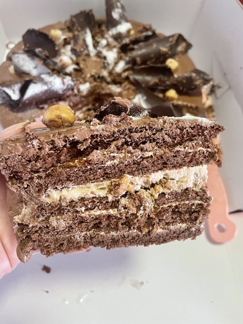 Close-up of a multi-layered chocolate cake slice with nuts.