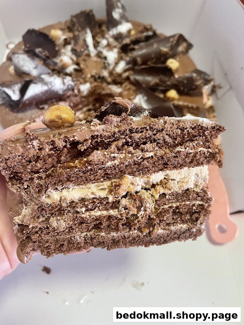 Close-up of a multi-layered chocolate cake slice with nuts.