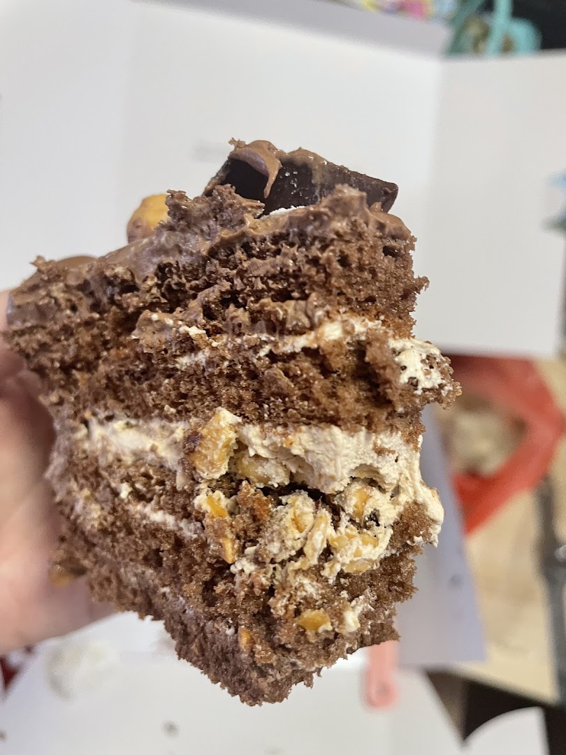 Close-up of a chocolate cake slice with cream and nuts.