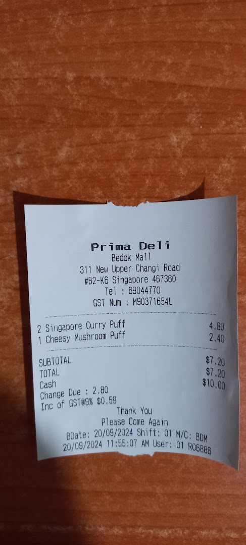 A paper receipt from Prima Deli showing purchase details and prices.