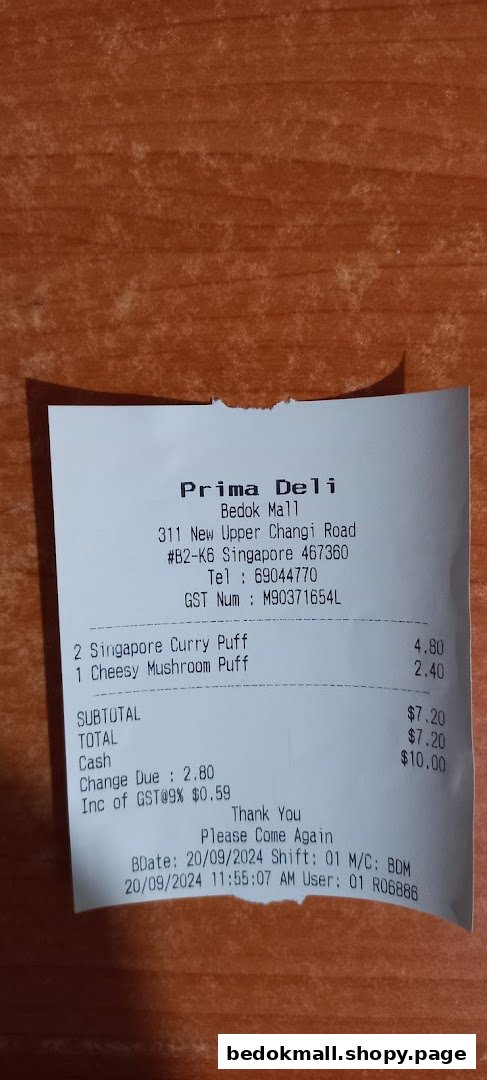 A paper receipt from Prima Deli showing purchase details and prices.