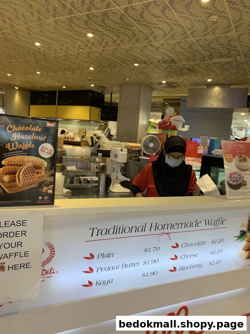 Shop counter with staff, waffle menu, and promotional signs.