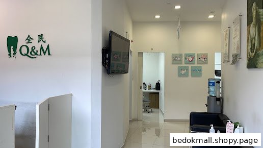 Interior view of a dental clinic waiting area with logo, TV, and seating.