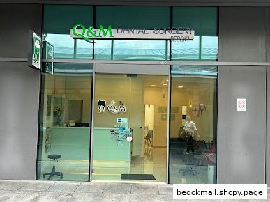 Exterior view of a dental surgery with glass entrance and signage.
