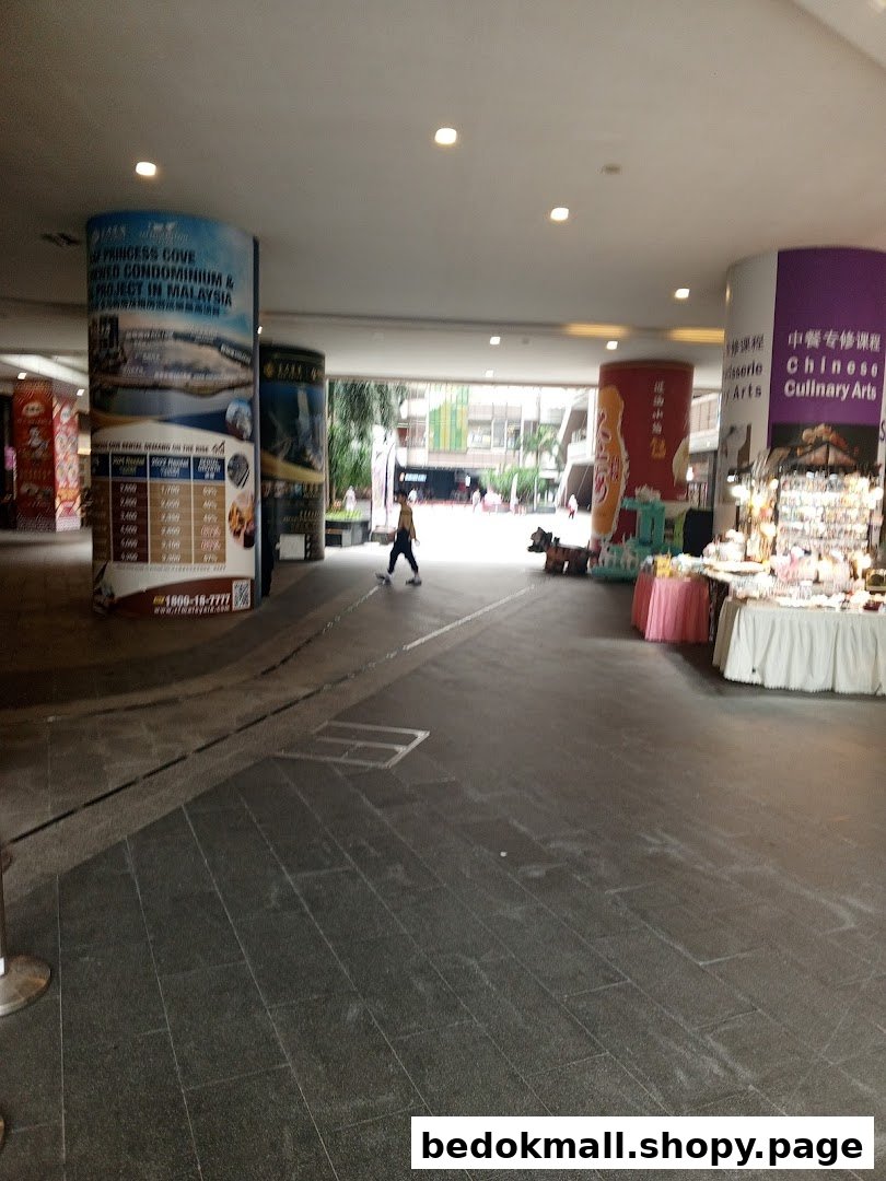 Covered walkway with pillars, a person, and market stalls.