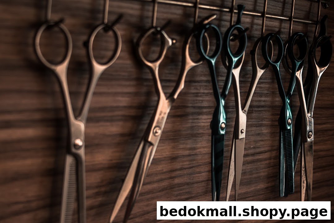 Multiple hair cutting scissors hanging on a wooden wall.