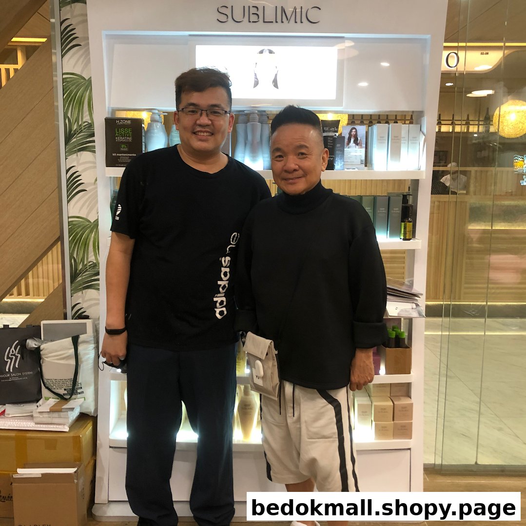 Two men standing in front of a hair product display shelf inside the salon.