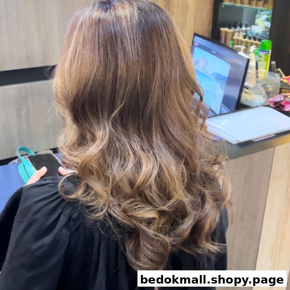 Back of person's head with long wavy hair in a salon setting.