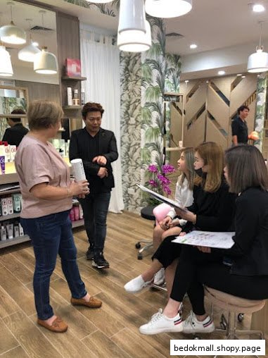 People gathered inside a hair salon, some holding papers, others standing.