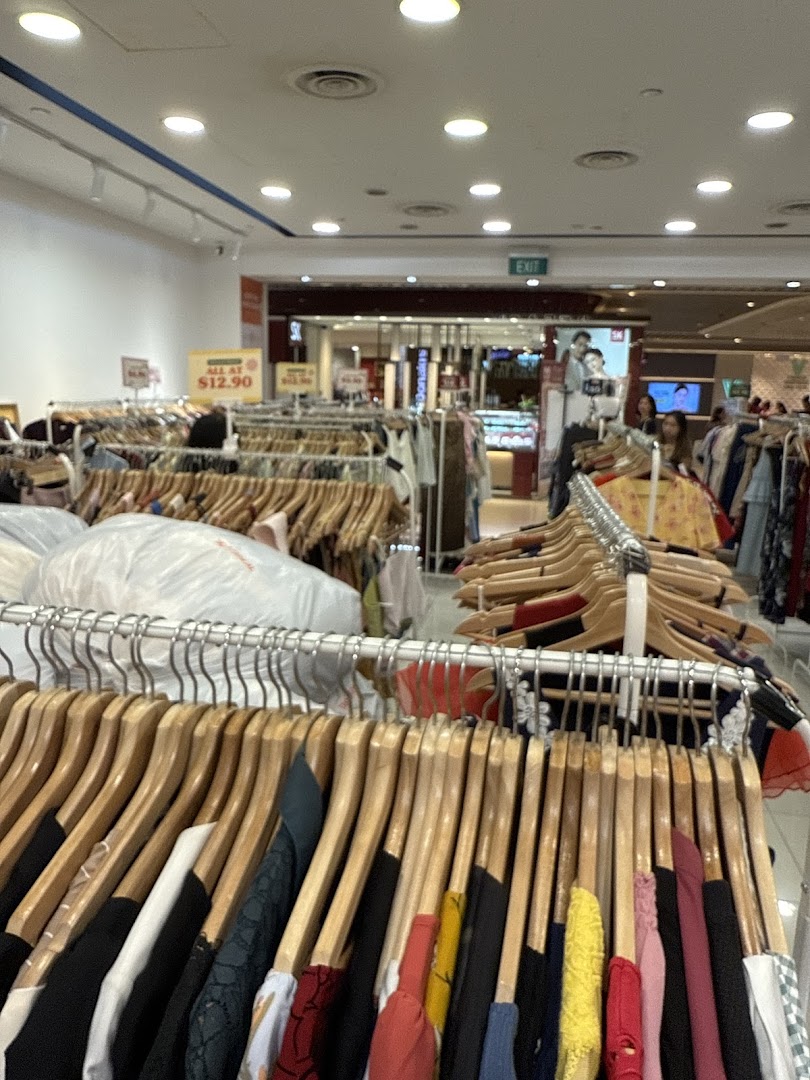 Interior view of a clothing shop with numerous racks of garments.