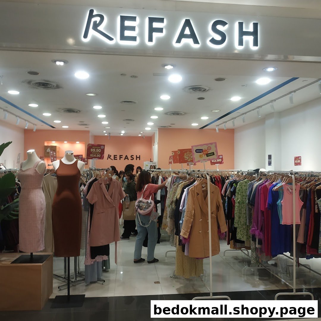 Entrance of a clothing shop with mannequins and racks of clothes.