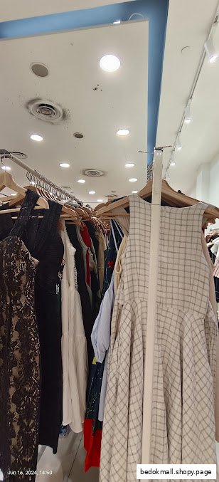 Clothing on racks inside a retail shop.
