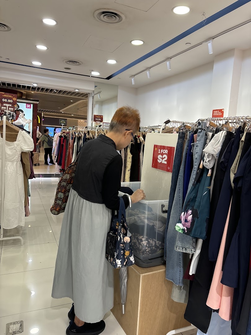 Customer browsing clothes inside a retail shop.