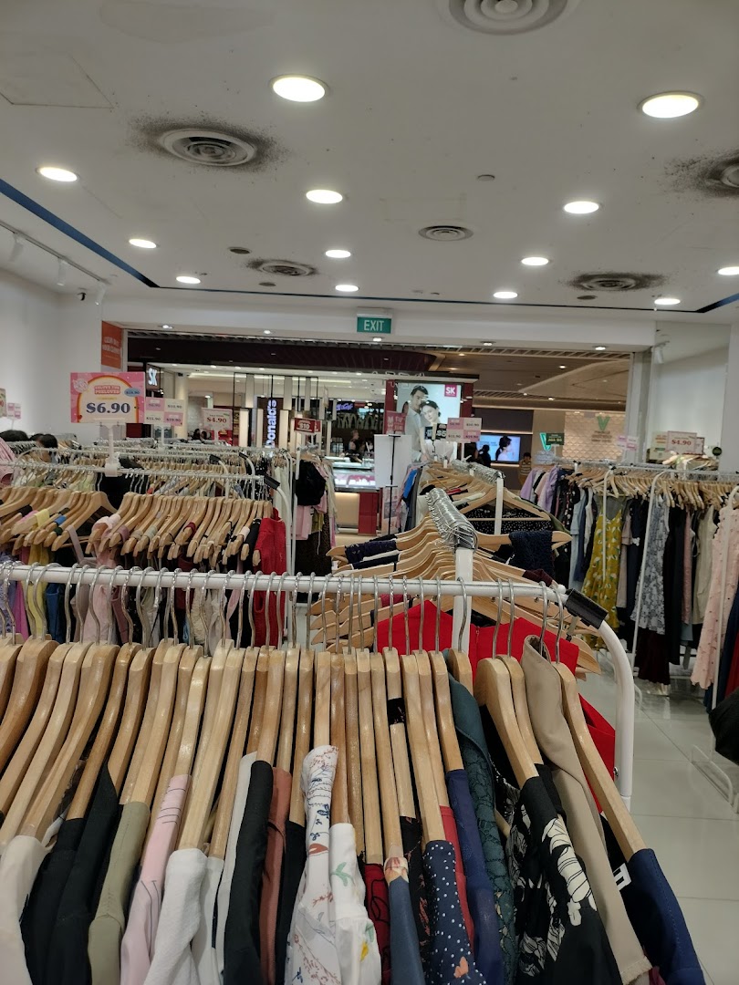 Interior view of a clothing store with racks of garments and price tags.