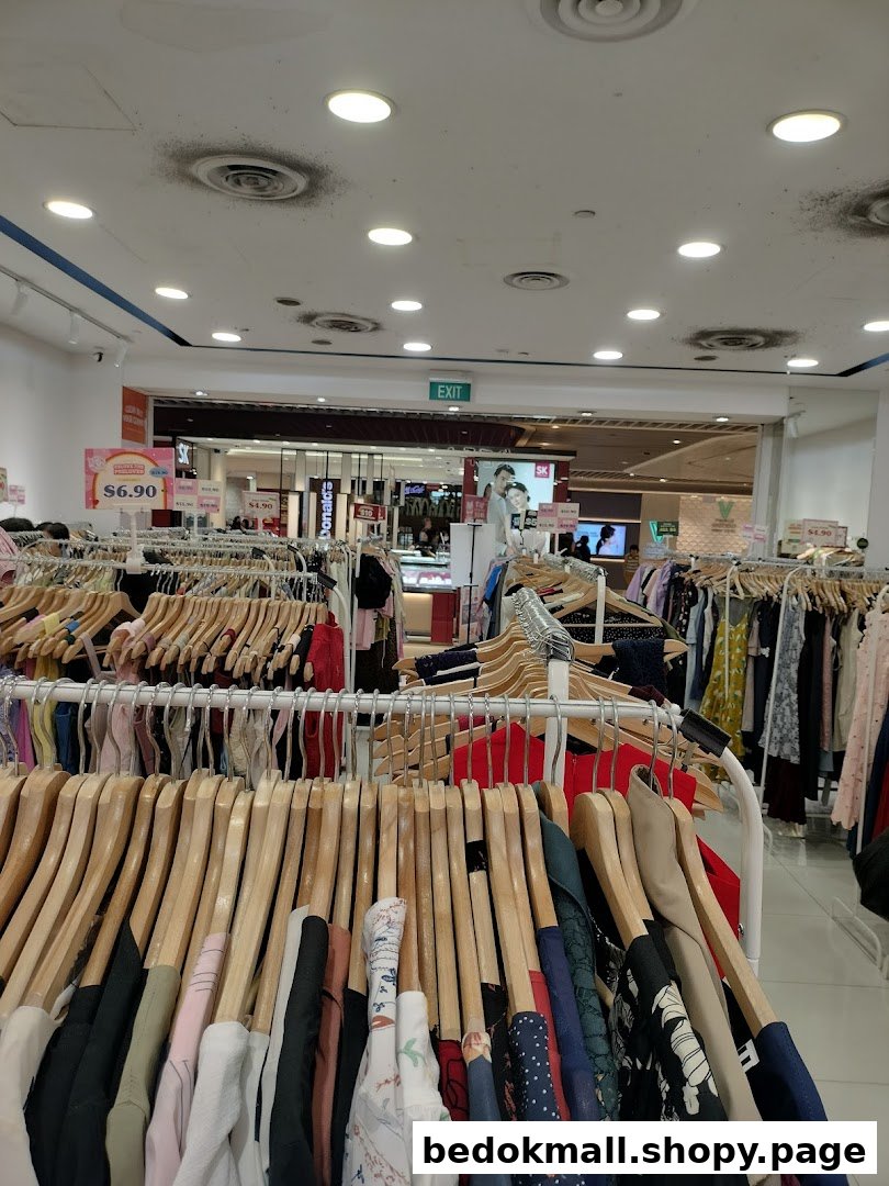 Interior view of a clothing store with racks of garments and price tags.
