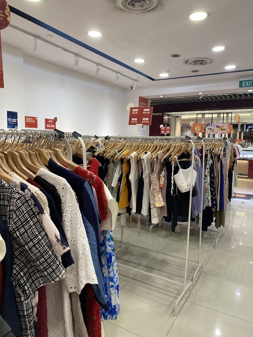Interior view of a clothing store with racks of garments for sale.
